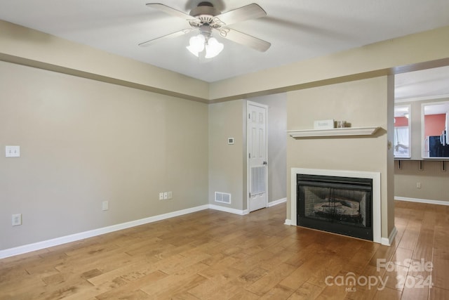 unfurnished living room with light wood-type flooring and ceiling fan