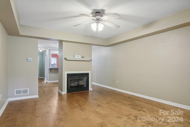 unfurnished living room with light wood-type flooring and ceiling fan