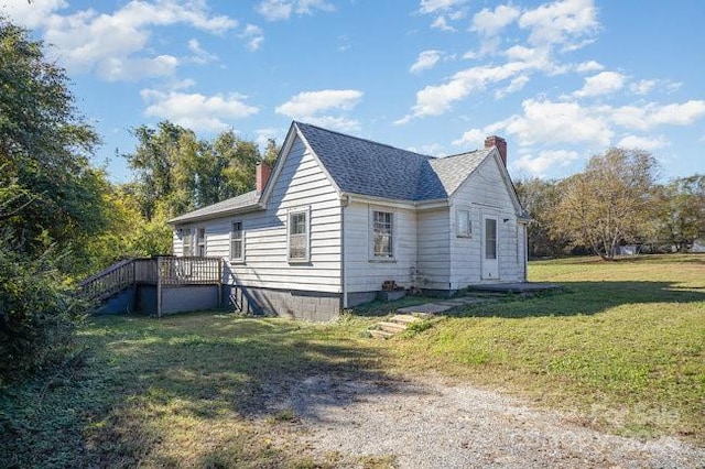 view of side of property with a lawn and a wooden deck