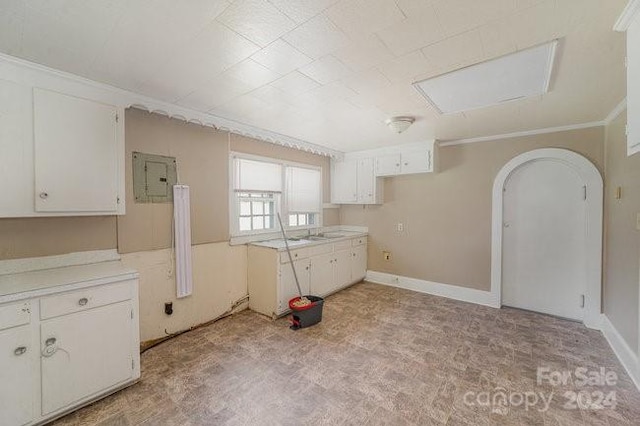 kitchen featuring white cabinets, crown molding, and electric panel