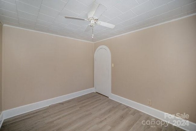 empty room featuring ceiling fan, light hardwood / wood-style floors, and ornamental molding