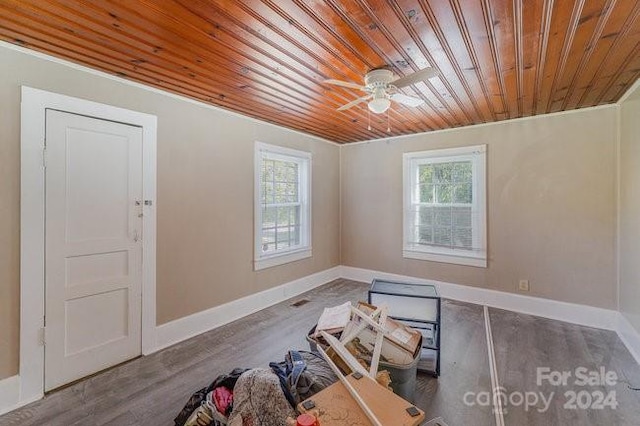 empty room with dark hardwood / wood-style floors, ceiling fan, and wood ceiling