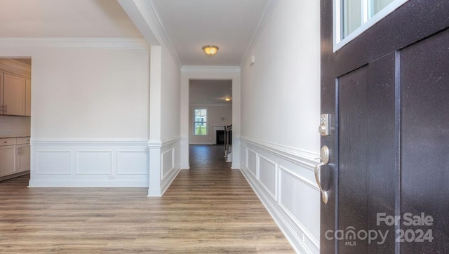 hallway featuring light hardwood / wood-style floors and crown molding