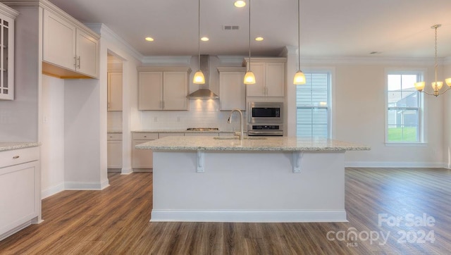 kitchen featuring appliances with stainless steel finishes, dark wood-type flooring, decorative light fixtures, and wall chimney exhaust hood