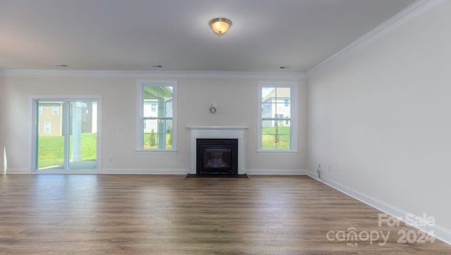 unfurnished living room with a healthy amount of sunlight, dark hardwood / wood-style flooring, and crown molding