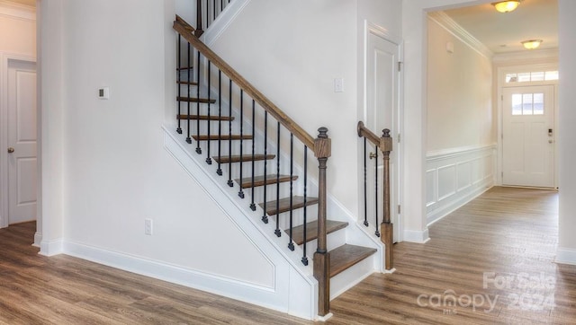 stairs with hardwood / wood-style flooring and ornamental molding