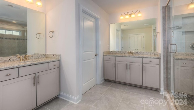 bathroom with tile patterned floors, vanity, and a shower with shower door