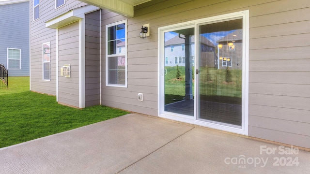 doorway to property featuring a lawn and a patio area