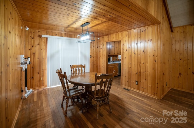 dining room with wood-type flooring, wooden walls, and wooden ceiling