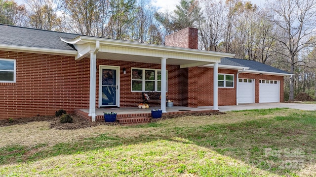 ranch-style home with a porch, a front yard, and a garage