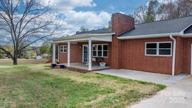 rear view of house featuring a patio area and a lawn