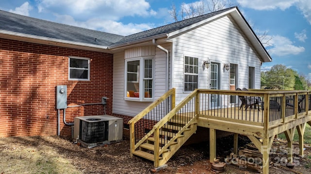 rear view of house with central AC and a deck