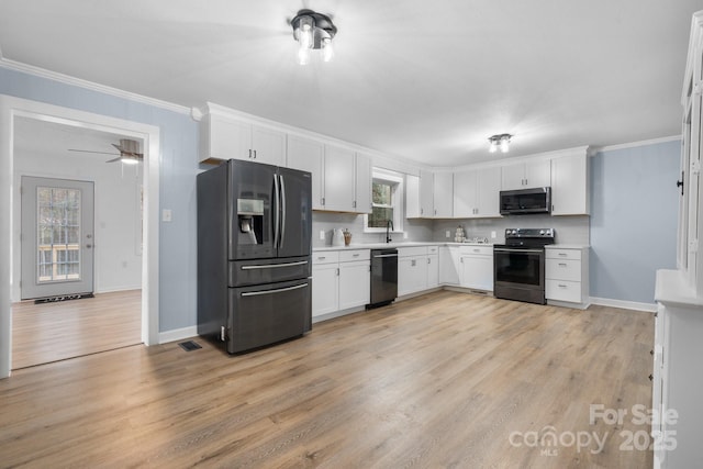 kitchen featuring light hardwood / wood-style floors, tasteful backsplash, white cabinetry, appliances with stainless steel finishes, and sink