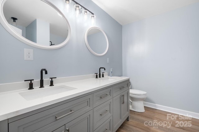 bathroom with toilet, wood-type flooring, and vanity