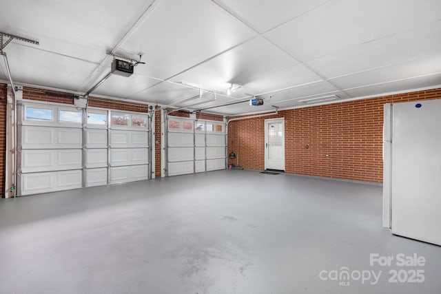 garage featuring white fridge and a garage door opener