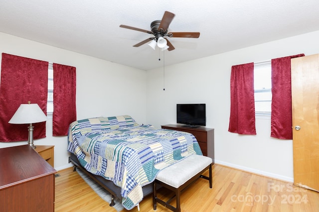 bedroom with hardwood / wood-style floors, a textured ceiling, and ceiling fan