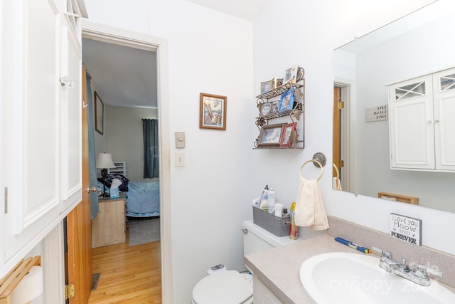 bathroom with vanity, hardwood / wood-style flooring, and toilet