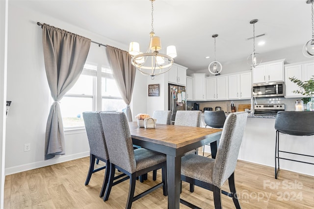 dining area with a chandelier and light hardwood / wood-style floors