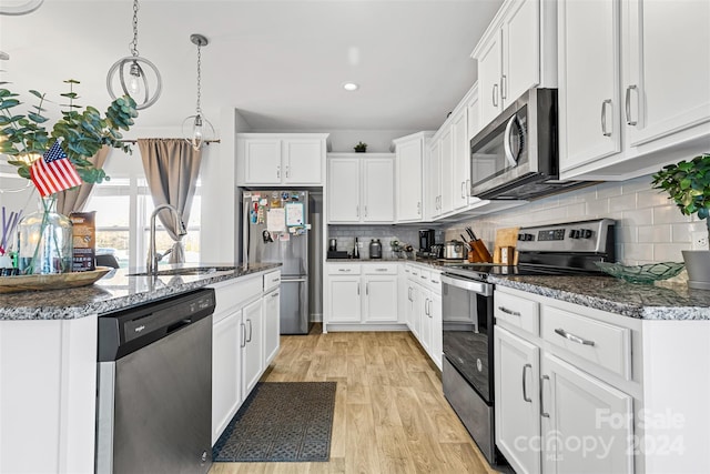 kitchen featuring white cabinets, appliances with stainless steel finishes, light hardwood / wood-style floors, and sink