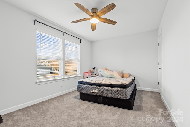 bedroom featuring ceiling fan, light carpet, and multiple windows