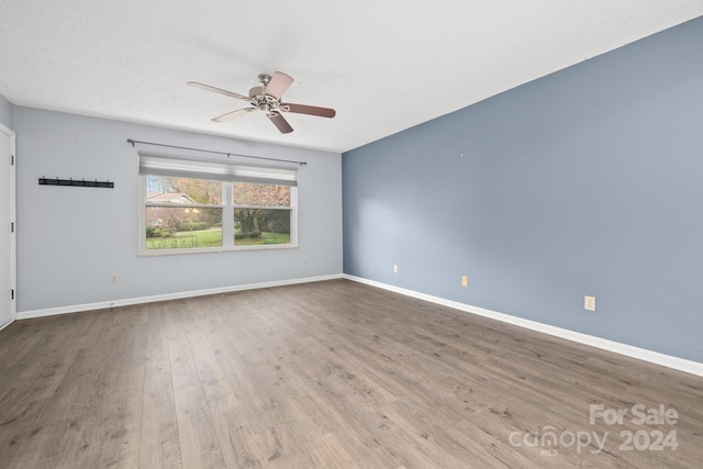 spare room featuring wood-type flooring, a textured ceiling, and ceiling fan