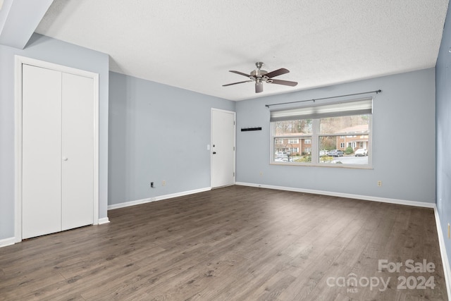 unfurnished bedroom featuring a textured ceiling, ceiling fan, and dark hardwood / wood-style floors