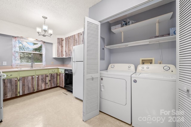 washroom with electric panel, sink, washing machine and dryer, a textured ceiling, and a chandelier