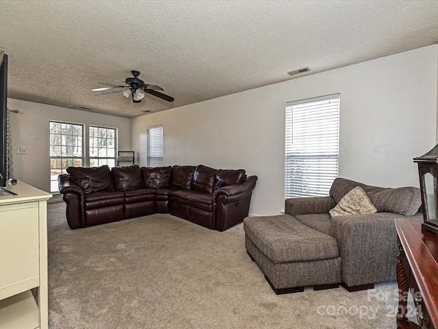 living room featuring carpet, a textured ceiling, and ceiling fan