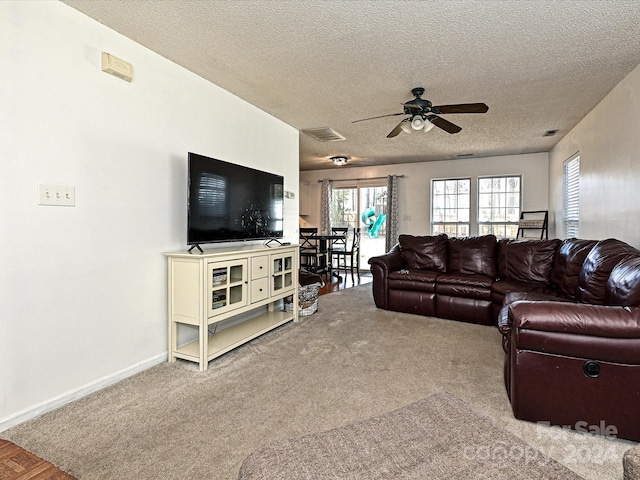 carpeted living room with a textured ceiling and ceiling fan