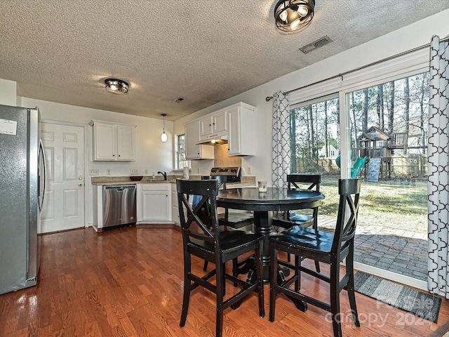 dining room featuring dark hardwood / wood-style flooring, a textured ceiling, and sink