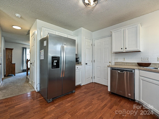 kitchen with appliances with stainless steel finishes, a textured ceiling, white cabinetry, and dark wood-type flooring