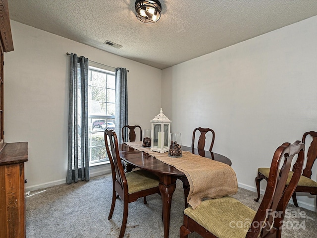 dining area featuring carpet floors and a textured ceiling