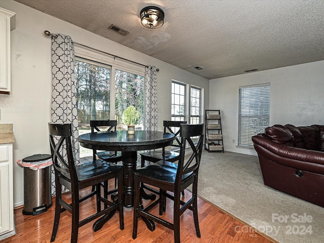 dining area featuring a textured ceiling and hardwood / wood-style flooring