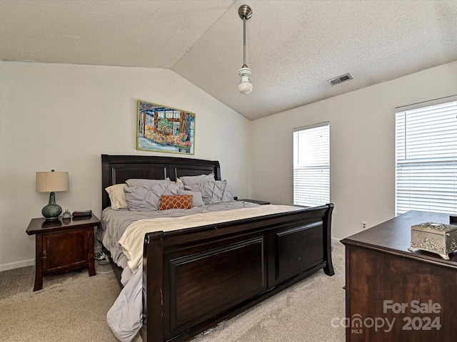 bedroom with a textured ceiling, light colored carpet, and lofted ceiling