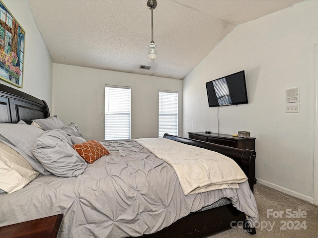 bedroom featuring a textured ceiling, carpet floors, and vaulted ceiling