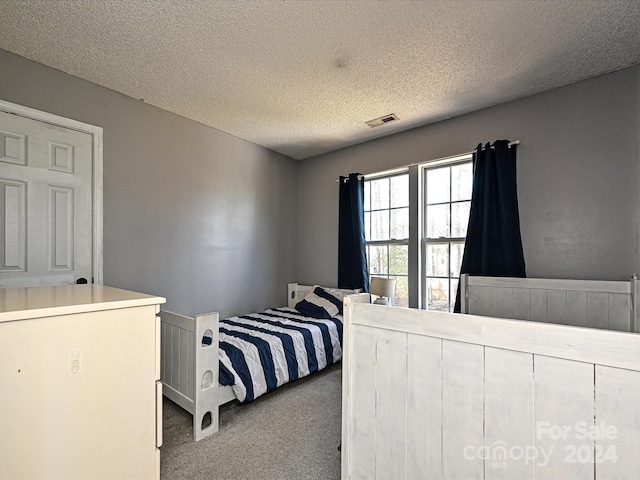 carpeted bedroom with a textured ceiling