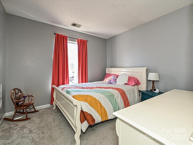 carpeted bedroom featuring a textured ceiling