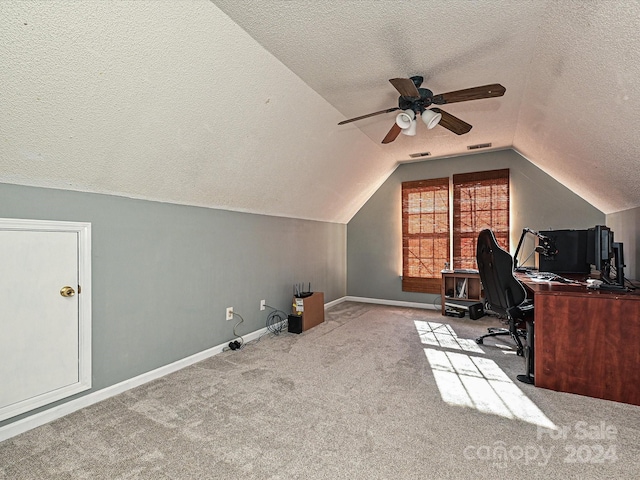 unfurnished office with vaulted ceiling, light carpet, ceiling fan, and a textured ceiling