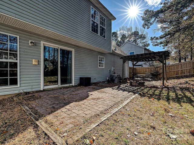 rear view of property featuring a pergola, a patio, and central AC unit