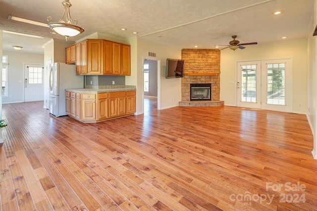 kitchen featuring white fridge, plenty of natural light, light hardwood / wood-style floors, and a textured ceiling