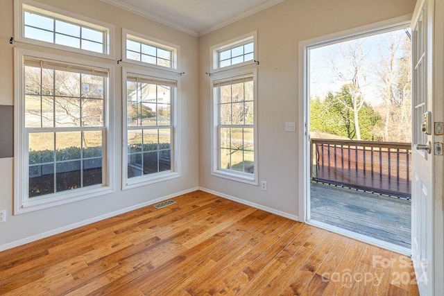 doorway with light hardwood / wood-style flooring and ornamental molding