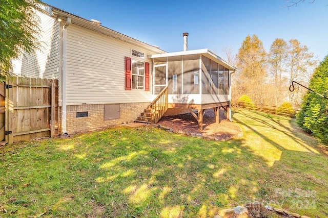 back of property with a sunroom and a yard