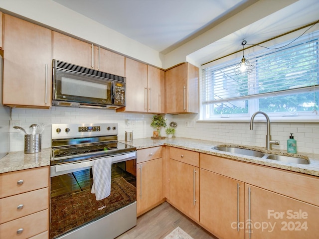 kitchen with light stone countertops, sink, backsplash, stainless steel electric stove, and light brown cabinetry