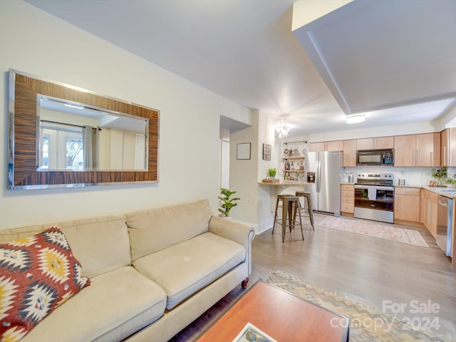 living room featuring an inviting chandelier and light hardwood / wood-style flooring