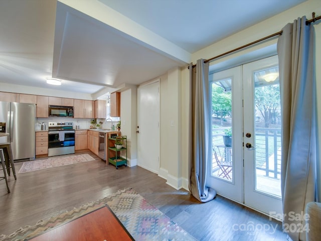 kitchen featuring sink, french doors, stainless steel appliances, and light hardwood / wood-style flooring