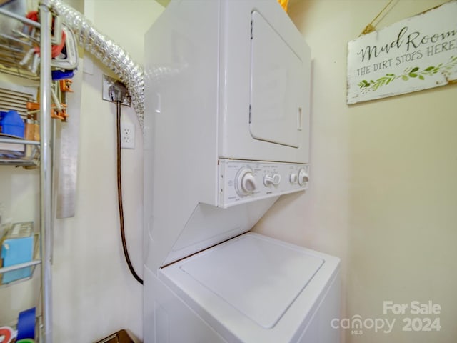 clothes washing area with stacked washing maching and dryer