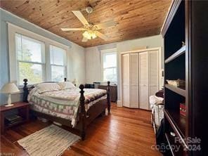 bedroom with multiple windows, ceiling fan, dark wood-type flooring, and wooden ceiling