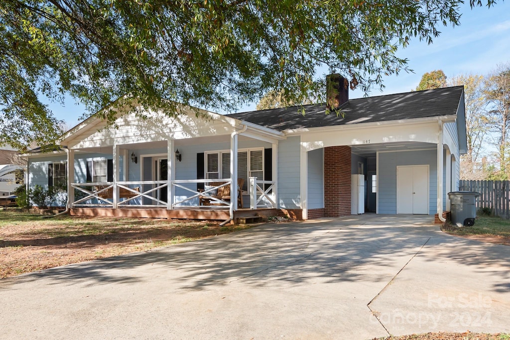 view of front facade with covered porch and a carport