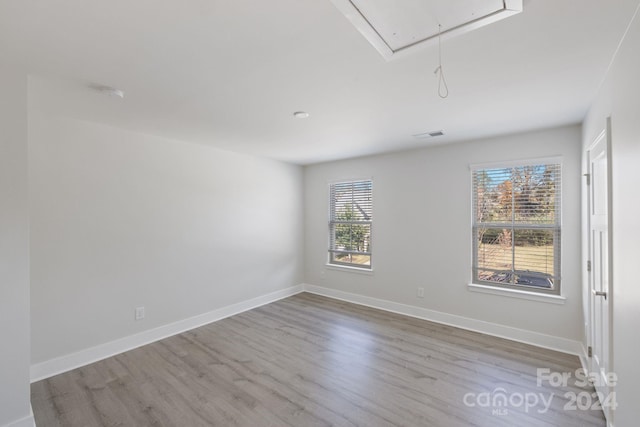 spare room featuring plenty of natural light and light hardwood / wood-style flooring