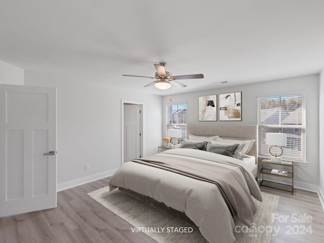 bedroom featuring multiple windows, ceiling fan, and light hardwood / wood-style floors